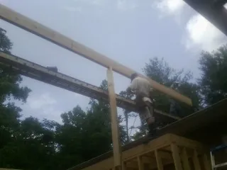 Carpenter setting a ridge beam over a new addition frame — Ice Dam Removal by Roofing Brothers in Claysburg