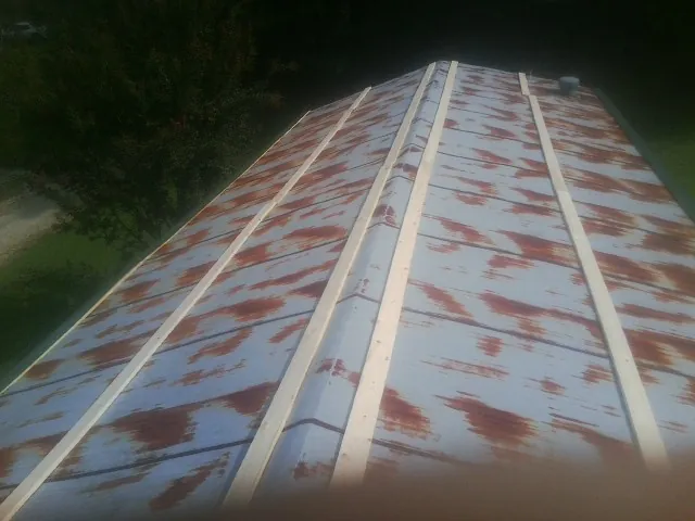 Rusted metal roof panels with new wood purlins before replacement — Storm Damage Roof Repair in Claysburg by Roofing Brothers