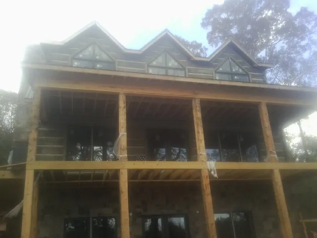 Dormers and porch framing on a large log home under construction — Roof Coating work by our crew in Claysburg