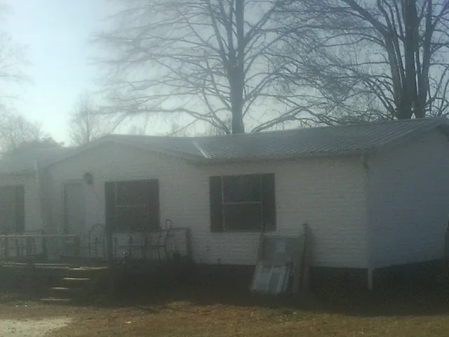New metal roof on a white painted brick home on a foggy morning in Claysburg