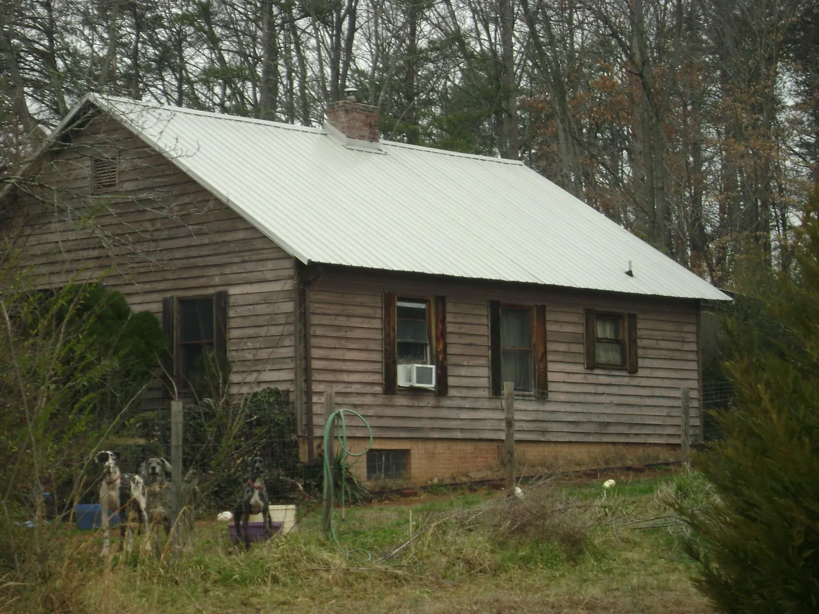 White metal roof on an old wood sided farmhouse, from a Asphalt Shingle Roof Repair job in Claysburg